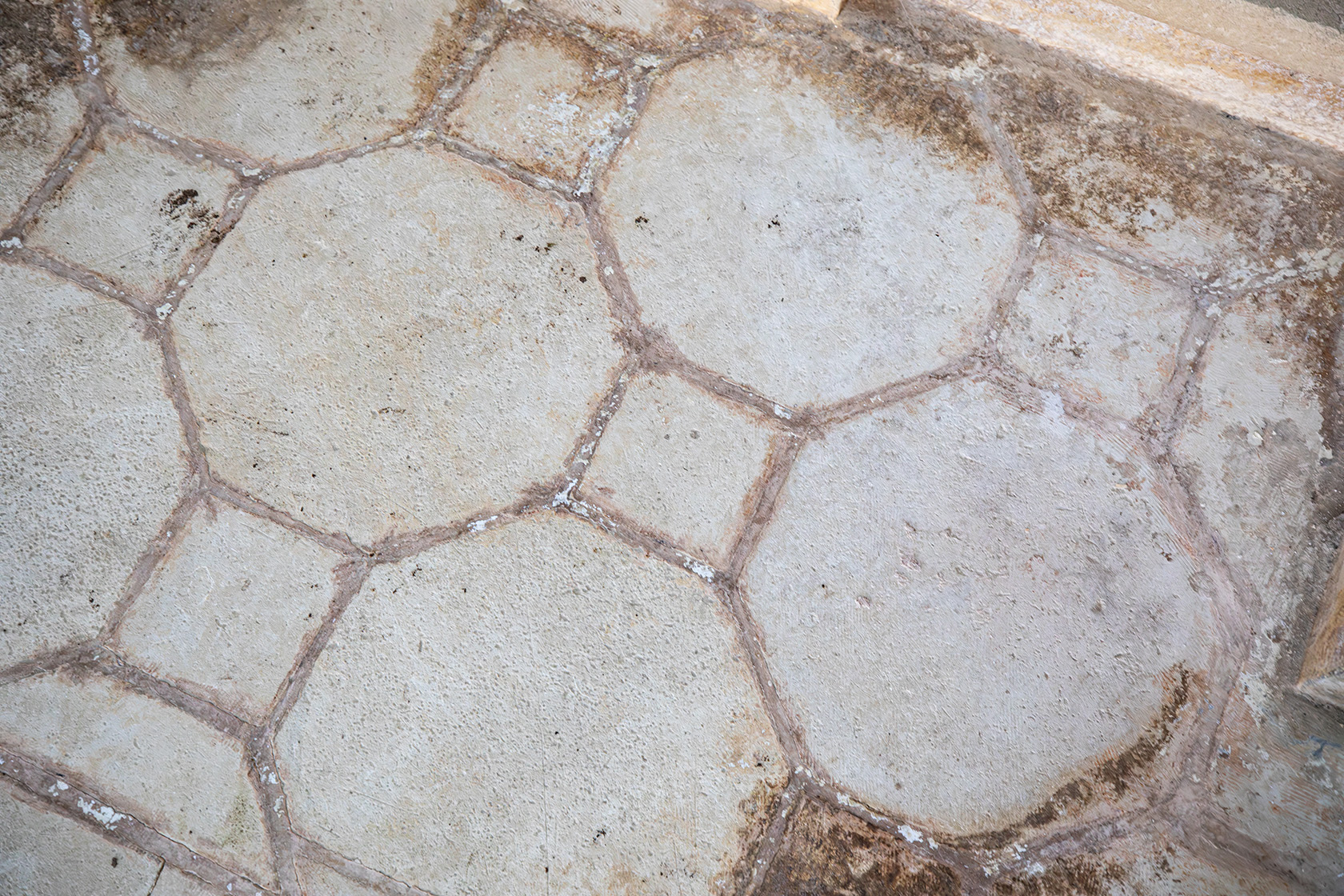 pavimento con formelle in pietra quadrate e ottagonali, disposte secondo un disegno geometrico regolare, tipico del gusto ottocentesco locale.